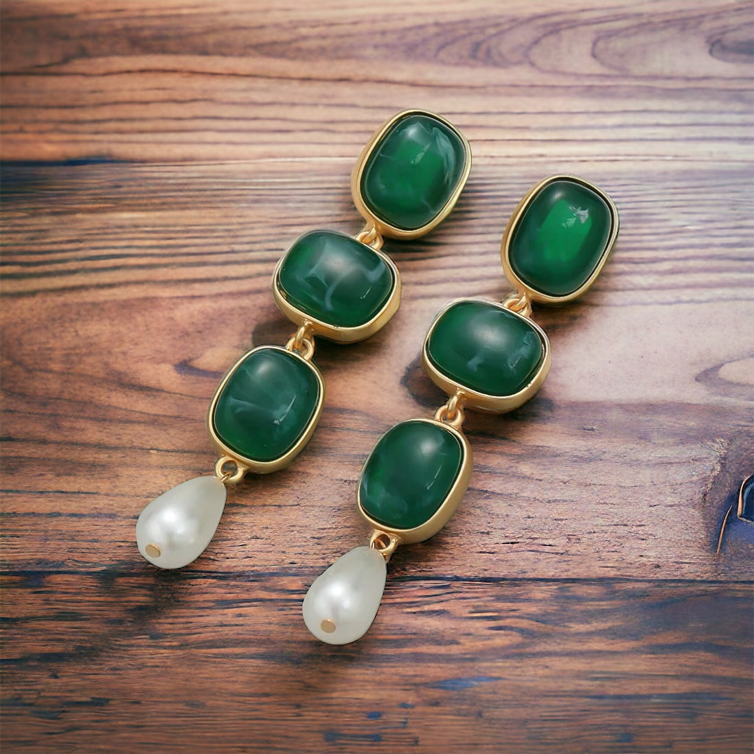 Green Enamel Danglers: 24K gold plated earrings featuring three rectangular green enamel stones and a single white pearl drop, shown on a wooden surface.