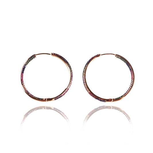 Shimmer Hoops: 18K gold plated hoop earrings adorned with small multicolored gemstones, shown on a white background with a soft reflection—ideal for anyone seeking affordable luxury jewelry.